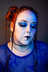 Futuristic woman with bold makeup, glowing blue eyes, circuit patterns on her face, braided hair...