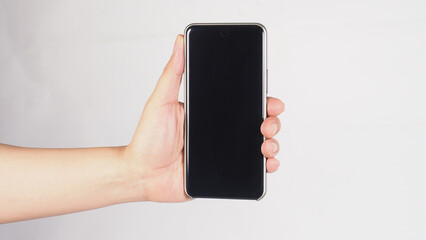 a smartphone vertically with one hand on white background.