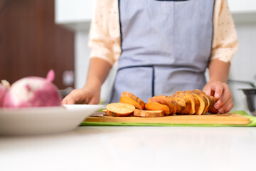 Chef slicing sweet potato for peruvian ceviche preparation in kitchen