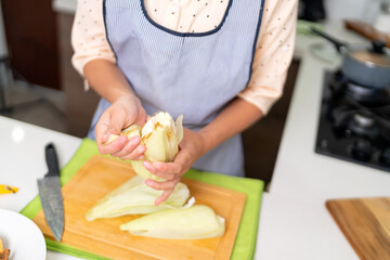 Chef removing husk from corn cob while preparing peruvian ceviche