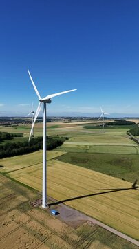 &eacute;oliennes en fonction au milieu des cultures en Lorraine avec un ciel bleu sans nuages