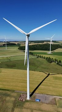 &eacute;oliennes en fonction au milieu des cultures en Lorraine avec un ciel bleu sans nuages
