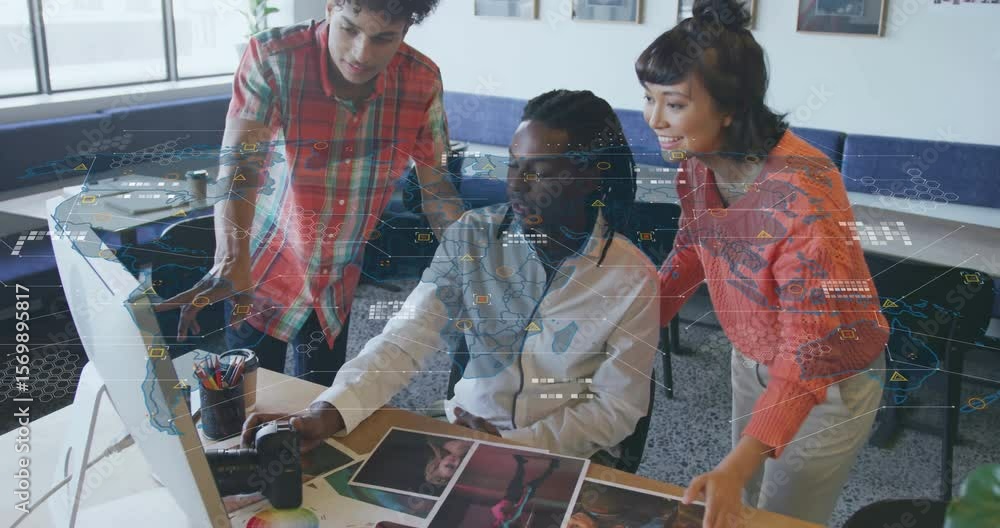 Poster design team shifting focus from prints to glowing data graphics after pointing, calibrating colors