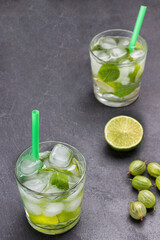 Two glasses of cold drink with lime, mint and ice.