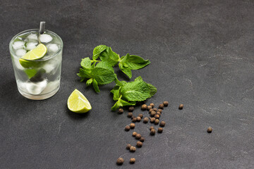 Glass of refreshing drink with lime, mint and ice.