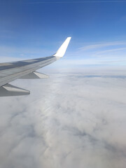 Scenic Flight Over Clouds with Airplane Wing View. A stunning in-flight view of an airplane wing...