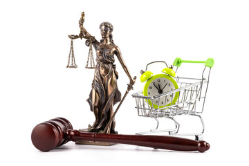 Judge's gavel, Themis figure and alarm clock in miniature shopping cart on white background