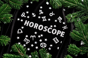 Abstract New Year background with the inscription Horoscope on a black velvet background.