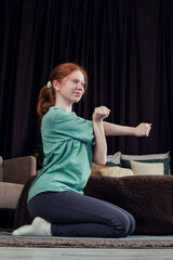 Girl practicing stretching exercises in a cozy living room during evening hours