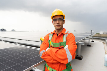 Solar panel rooftop, Rooftop solar power. Portrait of male engineer wear safety uniform, hardhat standing with crossed arms during inspecting installation quality of solar panel on rooftop of building