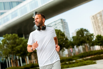 Running enthusiast enjoys morning jog in urban park near modern skyscrapers
