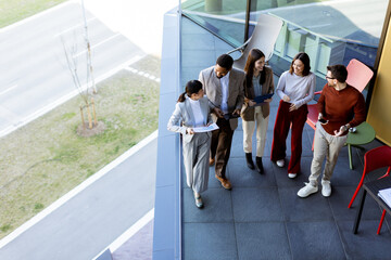 Team brainstorming and collaboration on a terrace during a sunny afternoon in a modern setting