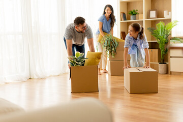 Family enjoys unpacking boxes while moving into their new home, filled with laughter and joy in the bright living room
