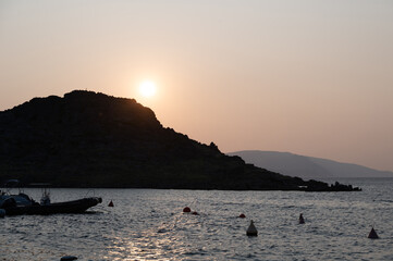 Sunset with a boat and an island by the sea