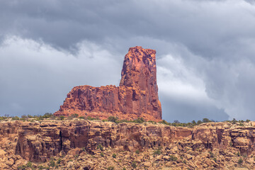 Rugged sandstone rock formation, pinnacle or Hoodoo rises prominently against a backdrop of cloudy...