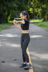 Portrait of beautiful female runner wearing workout clothes and warm up her body get ready for jogging in morning get good health. female runner warm up her body alone get ready for jogging in park.