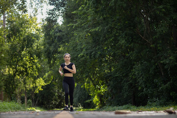 Portrait of Asian female runner jogging on street because jogging is a good exercise for good...