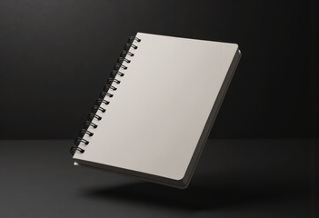 Blank spiral-bound notebook floating in mid-air against a dark background