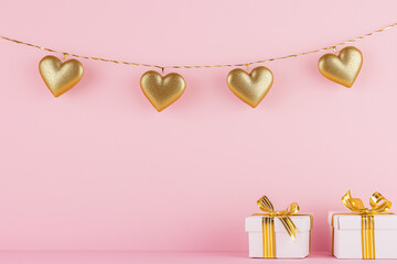 Golden hearts and gift boxes on pink background for valentine's day celebration and romantic concept