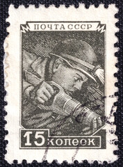 Miner in a mine extracting coal with Coal Hammer on a 1957 USSR postage stamp.