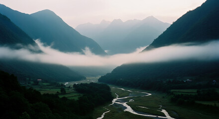 Misty valley with winding river at dawn. Foggy mountain landscape. Scenic nature view with low clouds. Tranquil outdoor scene for travel, adventure, and environmental concept