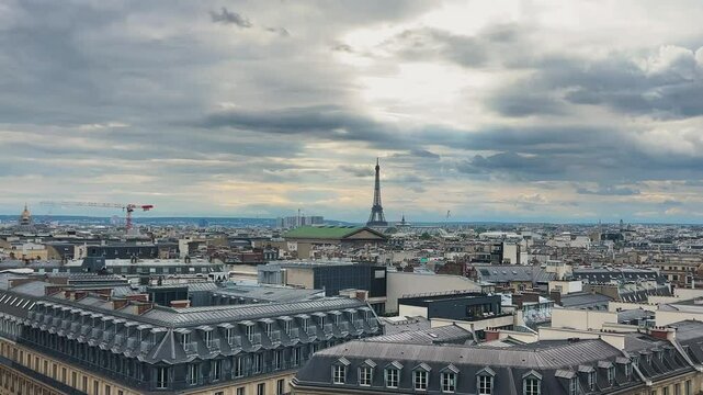 Panoramic top view of Paris, rooftops, Eiffel Tower and cloudy sky from the free observation deck on the roof of the Galeries Lafayette, France.