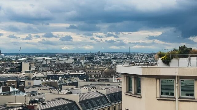 Panoramic top view of Paris, rooftops, Eiffel Tower and cloudy sky from the free observation deck on the roof of the Galeries Lafayette.