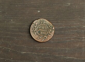 Old copper Indian coin on wooden table
