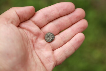 Small medieval coin of India in hand
