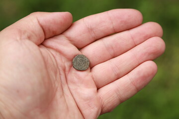 Small medieval coin of India in hand