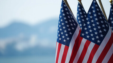 Fototapeta premium Close-up view of multiple American flags waving gently against a soft blue sky background.