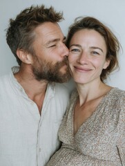 Linda pareja, dándose un beso cariñoso y posando ante la cámara. El hombre la ves a ella y ella sonríe.