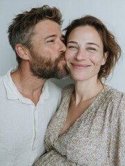 Obraz premium Linda pareja, dándose un beso cariñoso y posando ante la cámara. El hombre la ves a ella y ella sonríe.