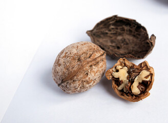 Side view close up of inshell and cracked walnuts with skin