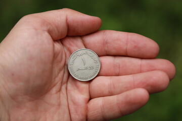 Fototapeta premium Coin one dirham of United Arab Emirates in hand