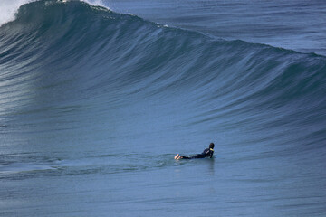 Surfer Facing a Wave in a beach