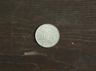 French coin one franc on wooden table