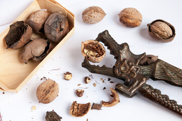Close view of box with inshell walnuts and skins and metal nutcracker dragon with half of open...