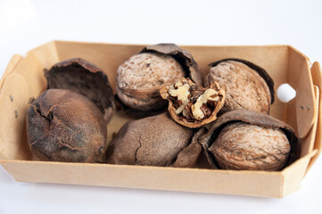 Side view of box with inshell walnuts and skins