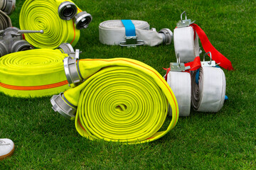 Colorful rolled fire hoses on green grass during a firefighting competition