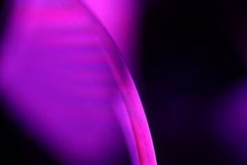 Bright pink liquid line on dark background, scientific abstraction 