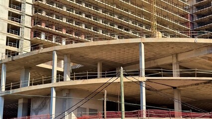 A dynamic and impressive construction site is showcasing multiple cranes and framework under clear...
