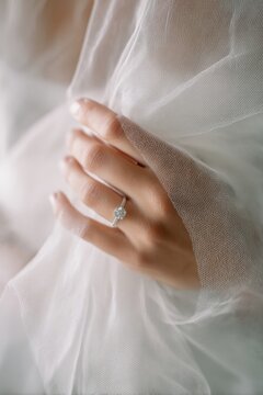 Concepto de boda y matrimonio, la mano de la novia con el anillo y el velo blanco.