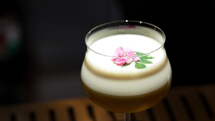 Closeup rotating in passion fruit smoothy cocktail glass serving special refreshing drink garnished...