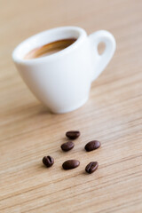 Cup of espresso coffee with coffee beans on the table, Artistic selective focus
