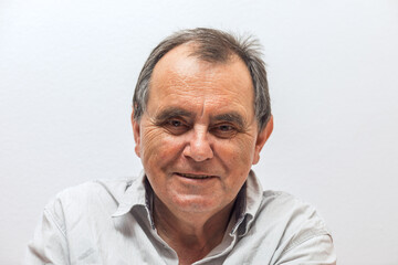 Elderly caucasian male smiling against white background