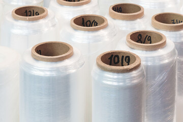 Rolls of transparent polyethylene stretch wrapping film packaging stand in a row ready for use,...