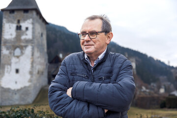 Caucasian elderly male in outdoor historic landscape with castle background