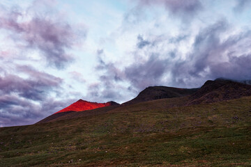 Peak glows with golden sunlight at dusk in County Kerry, ireland, on the walkway trail.
