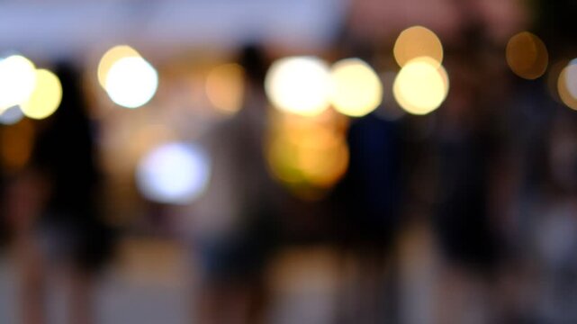 A blurry photo of a group of people walking down a street. The people are wearing shorts and the photo is in black and white. Scene is somewhat mysterious and somewhat nostalgic